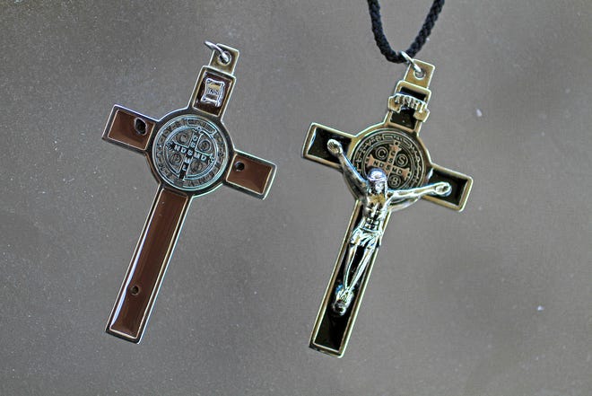 Father Mike Maginot used the crucifix on the right, seen on on Sept. 13, 2013, to see if demons were present in Latoya Ammons. When he placed the crucifix on her, she convulsed, showing their presence.He gave her the Benedictine crucifix on the left, and somehow the Christ figure disappeared.