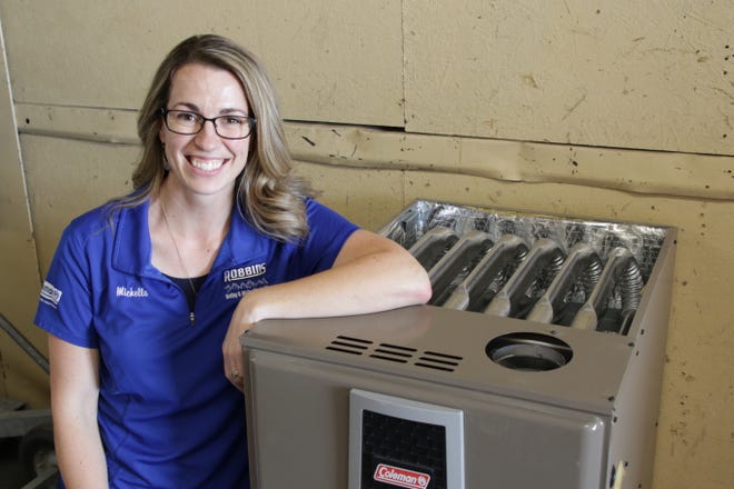 Michelle Robbins of Robbins Heating and Air Conditioning Inc. displays a furnace like the one the company will be donating to a local family in the firm's warehouse in Farmington on Oct. 31, 2019.