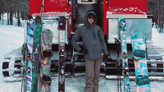 Jennifer Gurecki, CEO of Coalition Snow, poses next to some of the company's skis and snowboards.