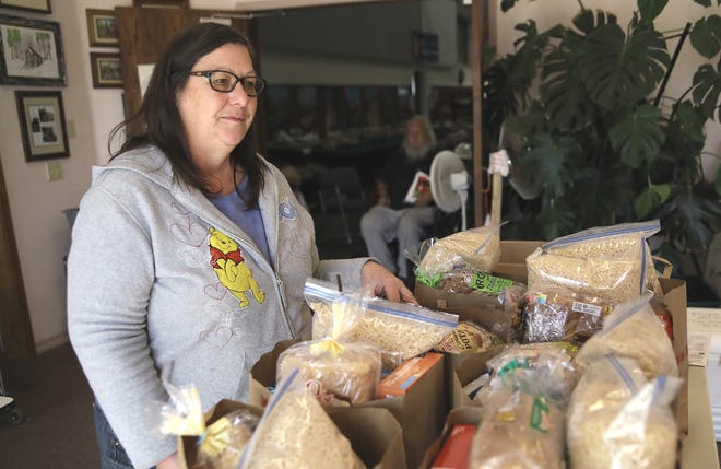 Doreen Fogle, a volunteer at the Magalia Community Church, helps distribute sacks of groceries to Camp Fire victims on Wednesday, Oct. 30, 2019.