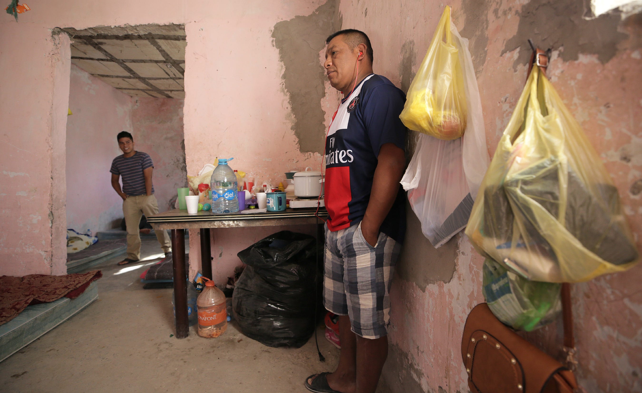 Francisco Sical, right, found shelter with his 10-year-old daughter in summer 2019 in a half-finished house in Juárez. A dozen migrants from his native Guatemala, as well as Honduras and El Salvador, waited on court hearings in the USA under the Trump administration's Migrant Protection Protocols.