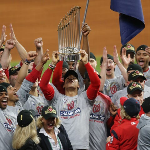 Juan Soto hoists the Commissioners Trophy after de