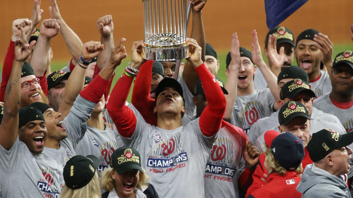 Juan Soto hoists the Commissioners Trophy after defeating the Astros in Game 7.