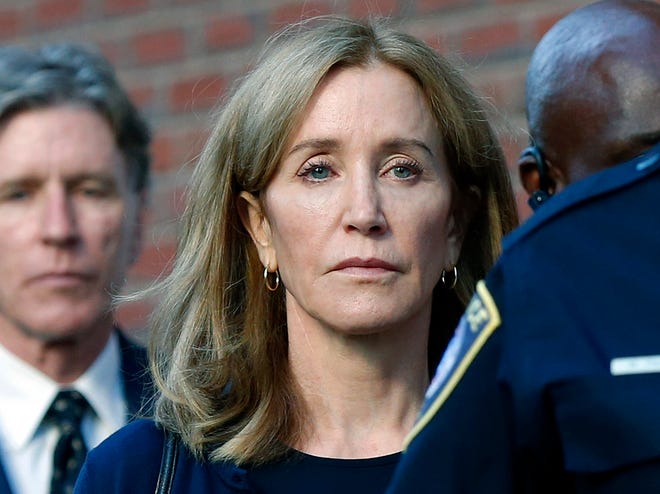 In this September 13, 2019 file photo, actress Felicity Huffman leaves federal court in Boston with her brother, Moore Huffman Jr., after she was convicted in a recruitment bribery scandal university students nationwide.  Huffman was sentenced to 14 days in federal prison in Dublin, California, but was released after serving 10 days.