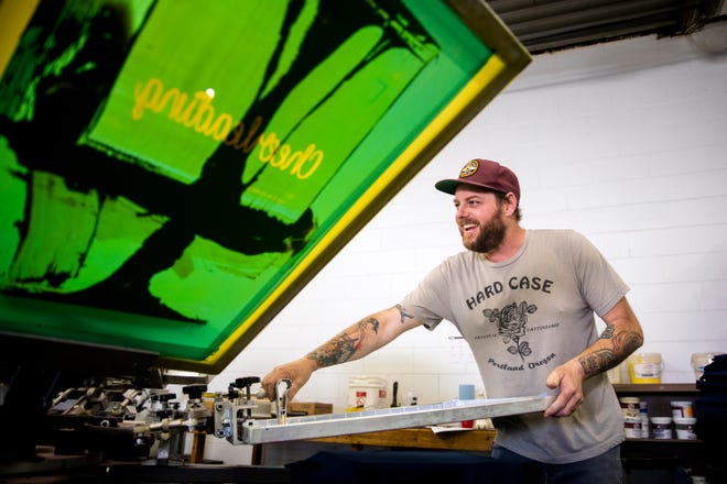 Brandon Swinehart of Wyoming, screen-presses T-shirts the shop he co-founded with his wife, SRO Prints, in Evendale. Swinehart has been in recovery for about 14 years and hires people with addiction to give 'second chances.'