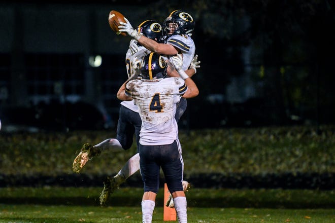 DeWitt's Andrew Debri celebrates a touchdown with teammates Chandler Murton, left, and Grant Uyl on Nov. 1. DeWitt is hoping to continue its dominating season in December.