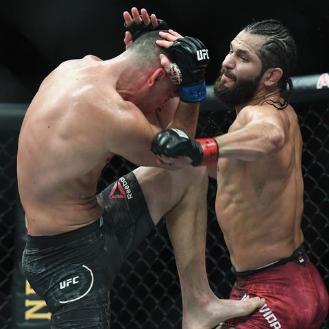 Jorge Masvidal, right, throws a punch at Nate Diaz