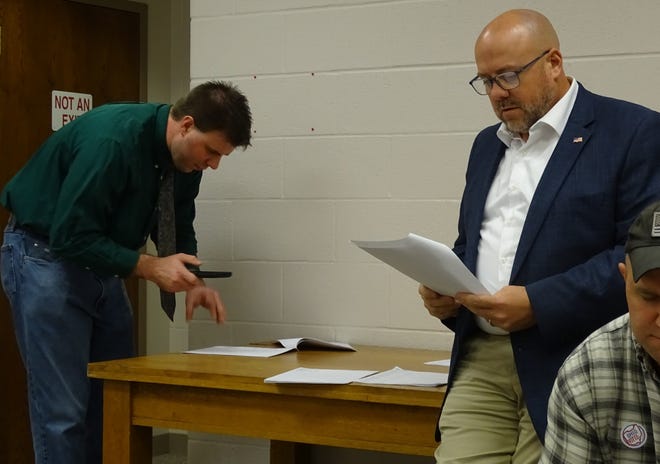 Kevin Myers, right, who won reelection as an at-large member of Bucyrus City Council, checks out newly posted election results Tuesday night at the Crawford County Board of Elections. At left is attorney Michael Bear, county chairman of the Republican party.