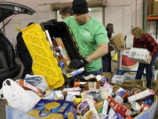 Volunteers organize food donations on their way to the Greater Lansing Food Bank.