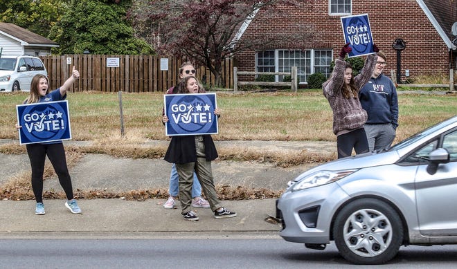 Lauren Payne, from left, Bella Karn, Victoria Garrard, Ella Bratcher and Connor Satterly encourage passing motorists to vote while standing on the sidewalk on W. Parrish Avenue, Tuesday, Nov. 5, 2019, in Owensboro, Ky. The five, all with the Wendell H. Ford Statesmanship Academy, and, other members of the organization, stood with signs at busy intersections in the city throughout election day. (Greg Eans/The Messenger-Inquirer via AP)