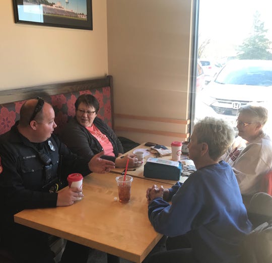 Brandon Police officer Zachary Hagstrom, left, talks with customers during Brandon's Coffee with a Cop event at Scooter's on Thursday, Oct. 31.