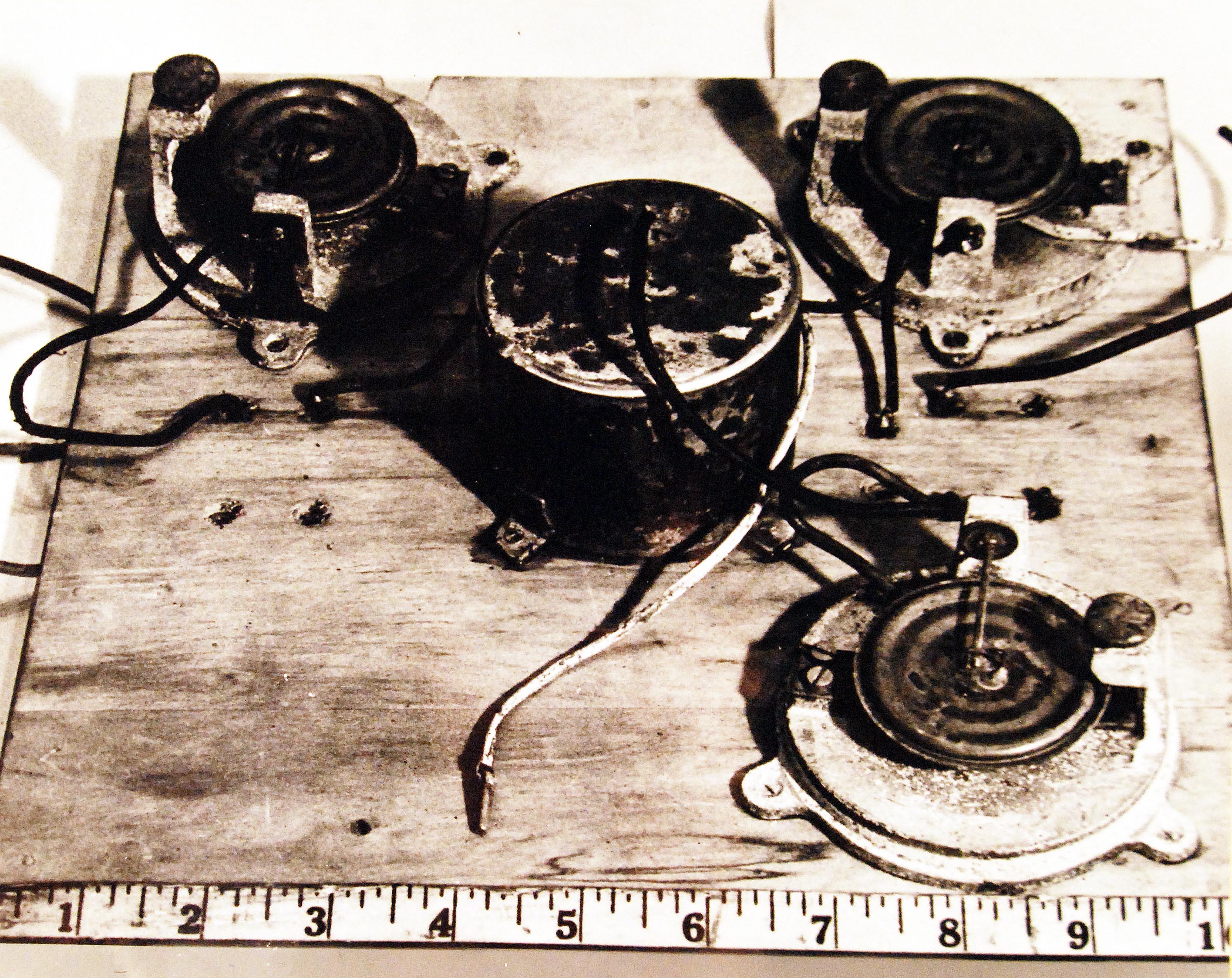 A master aneroid (center, covered) controls the Japanese Fu-Go balloon’s minimum altitude. The others are used if the master fails. Uncovered aneroids show how the electrical current circuit is closed when increased air pressure forces down the disk, bringing a wire loop in contact with a horizontal pin which passes through center of the loop.  This fired off a small charge that would drop a ballast sand bag, helping to keep the balloon at the desired altitude for the long journey across the Pacific to North America.