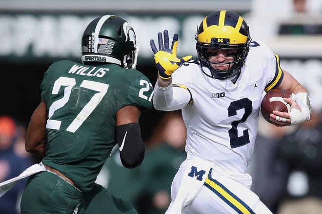 U-M's Shea Patterson tries to get around the tackle of MSU's Khari Willis at last year's Spartans-Wolverines game in East Lansing.
