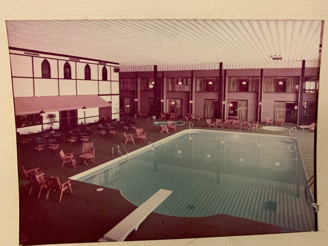 A view of The Highlander's indoor pool and sitting area. On both ends of the pool, hotel rooms overlook the water.