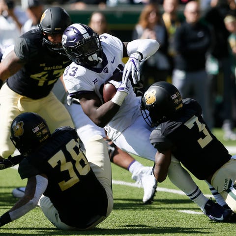 TCU running back Sewo Olonilua is tackled by Baylo