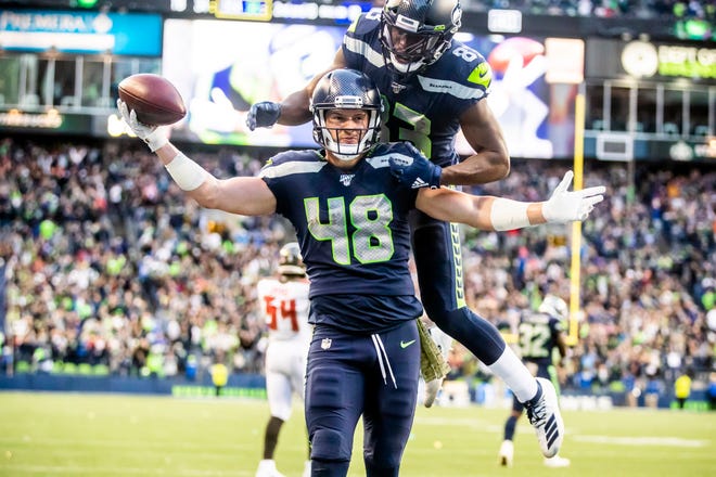 Seahawks tight end Jacob Hollister celebrates after scoring the winning touchdown in overtime with wide receiver David Moore on his back at an NFL football game against the Tampa Bay Buccaneers, Sunday, Nov. 3, 2019, in Seattle.