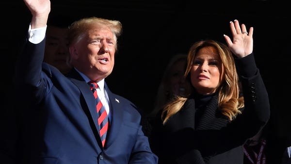 President Donald Trump and Melania Trump wave to f