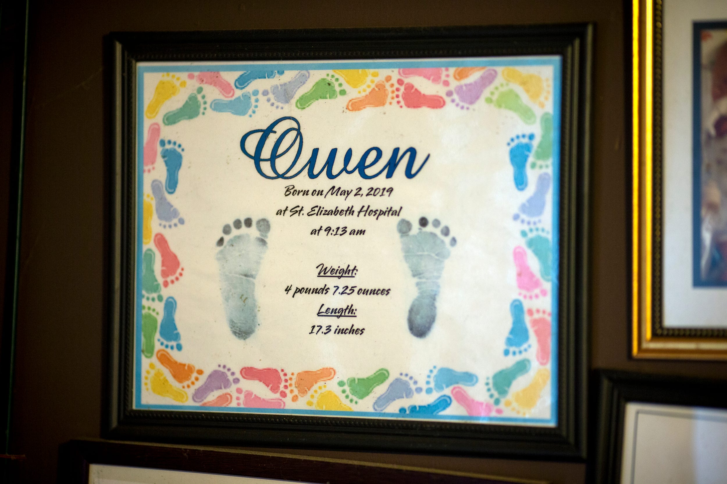 Tabitha Bates displays her deceased son Owen's footprints in her family's home.