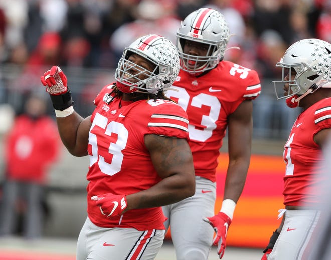 Absent their leader, Chase Young, Ohio State defensive linemen Davon Hamilton (53) and Zach Harrison (33) celebrate one of the Buckeyes' seven sacks in last Saturday's 73-14 rout of Maryland.