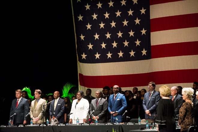 City Council members stand for the national anthem during Inauguration at the Montgomery Performing Arts Center in Montgomery, Ala., on Tuesday, Nov. 12, 2019.