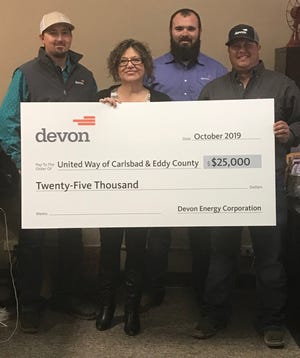 Devon Energy employees Christopher West, Brandon Boyles and Wes Ryan present a $25,000 check to Linda Dodd, director of the United Way of Carlsbad and South Eddy County.