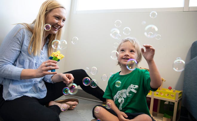 Emily Schworer, lab coordinator at the Developmental Disabilities Research Laboratory, uses bubbles to play with a research participant.