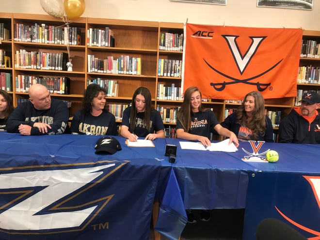 Madison's Leah Boggs, at center right, and Sloan Kiser, center left, sign national letters of intent to play Division I college softball at Virginia and Akron, respectively, on Wednesday afternoon at Madison High School.