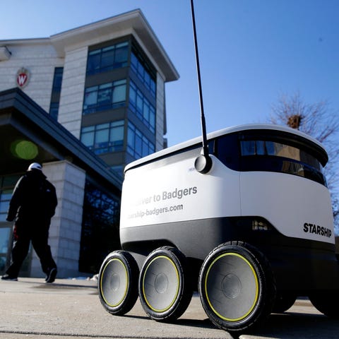 A robot in front of Dejope Residence Hall on the U
