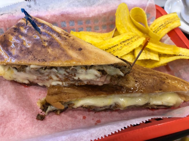 The Cuban sandwich ($13) from Van Van Cuban Cafe in Naples is layered with slow roasted-pork, ham, Swiss cheese, mustard, mayo and pickles.