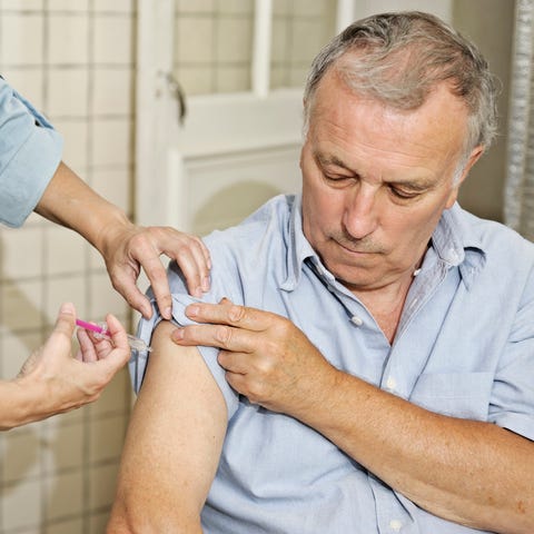 Nurse giving man vaccination in the arm