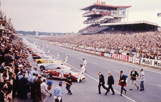 The start of the 1966 24 Hour of Le Mans. Having waved the starting flag, Henry Ford II (first suit on the left) hustles across the track while the drivers spring to their cars.