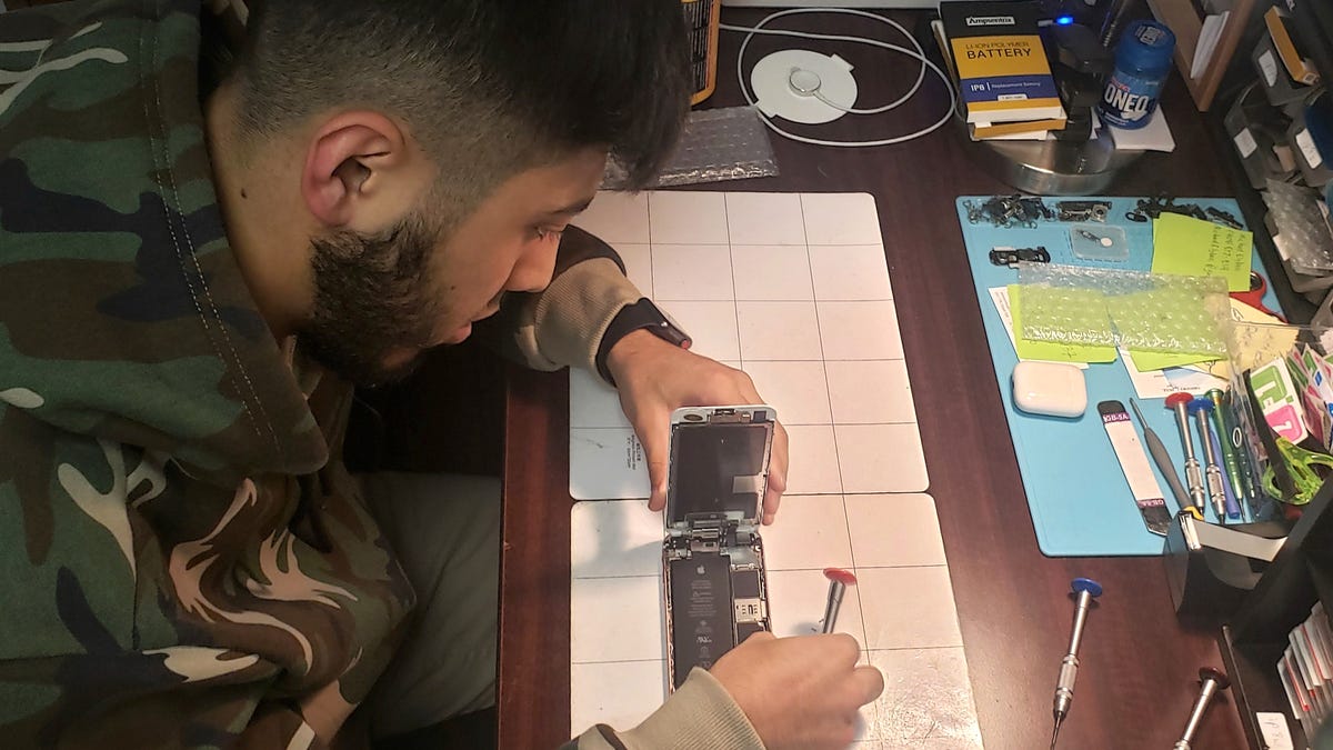 Muhammad Hoshur, 23, fixes phones and other electronic devices at his repair shop, H&M FIX, in downtown Washington, D.C.