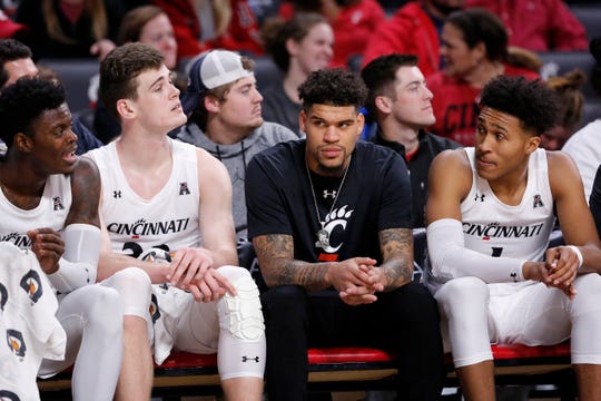 Cincinnati Bearcats guard Jarron Cumberland (34) sits on the bench in plain clothes in the second half of the NCAA basketball game between the Cincinnati Bearcats and the Alabama A&M Bulldogs at Fifth Third Arena in Cincinnati on Thursday, Nov. 14, 2019. The Bearcats won 85-53.
