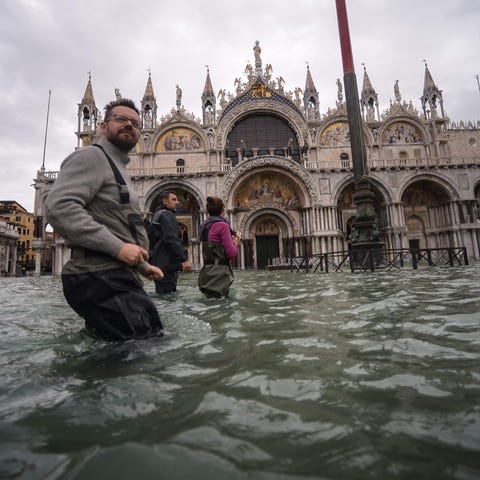 People walk across the flooded St. Mark's Square, 