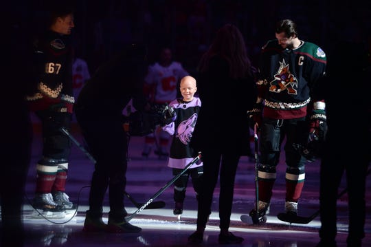 Nov 16, 2019; Glendale, AZ, USA; Cancer patient Leighton Accardo joins the Arizona Coyotes during the national anthems prior the first period against the Calgary Flames at Gila River Arena.