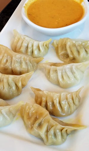 Nepali momo dumplings with a spiced dipping sauce at Yak & Yeti Himalayan Cuisine.