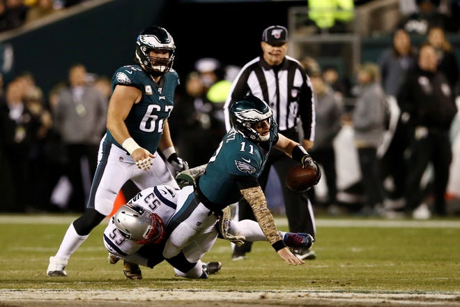 Philadelphia Eagles' Carson Wentz (11) is tackled by New England Patriots' Kyle Van Noy (53) during the first half of an NFL football game, Sunday, Nov. 17, 2019, in Philadelphia. (AP Photo/Michael Perez)