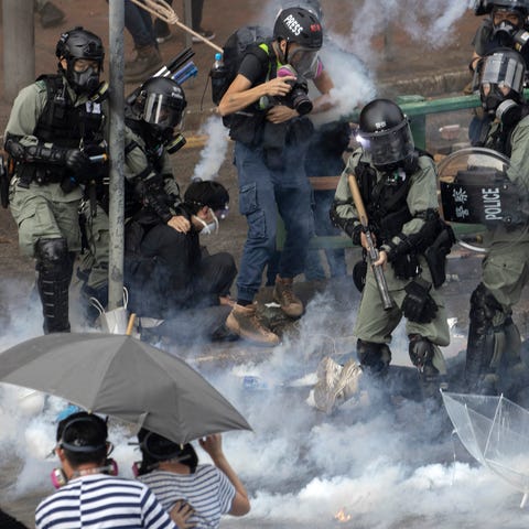 Riot police detain protesters amid clouds of tear 