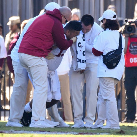 Tua Tagovailoa is helped off the field after his i