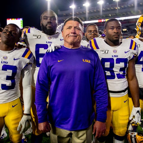 LSU players and coach Ed Orgeron stand together af