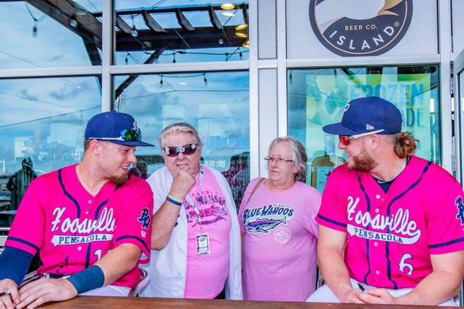 Ryan Costello (left) and Travis Blankenhorn (right) are pictured with Pensacola Blue Wahoos' employees in an undated photo. Costello unexpectedly passed away earlier this week.