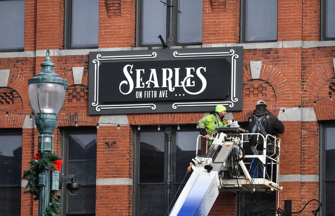 Ben Arneson and Adrion Jennen of Indigo Signworks install a new sign for Searles on Fifth Ave. Wednesday, Nov. 20, 2019, in St. Cloud. They earlier removed the former D.B. Searle's sign from the building. The old sign is being sold through a sealed-bid auction. 