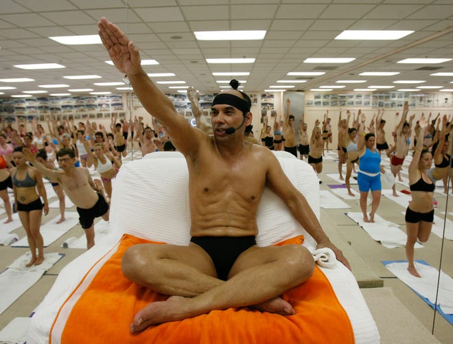 Bikram Choudhury (who goes by Bikram), seen here in 2006, has a chair at the front of his hot yoga class, which is filled with hundreds of students.