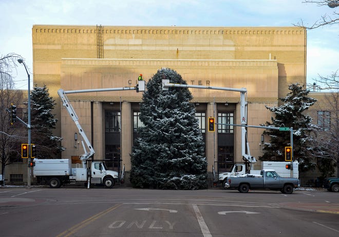 City crews place lights on the Christmas tree at the Civic Center.