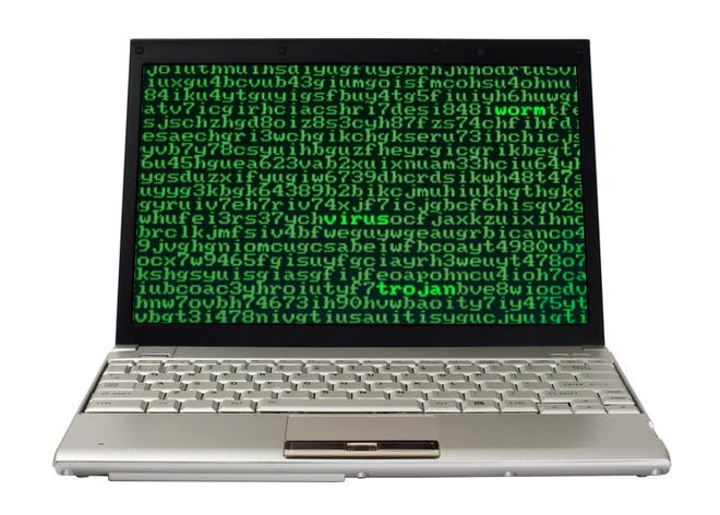 Laptop screen full of alphanumerics with the words virus, worm and trojan emphasized