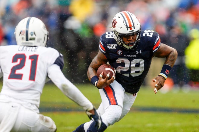 Auburn running back JaTarvious Whitlow (28) carries the ball as he tries to get past Samford defensive back Joshua Carter (21) during the first half of an NCAA college football game, Saturday, Nov. 23, 2019, in Auburn, Ala. (AP Photo/Butch Dill)