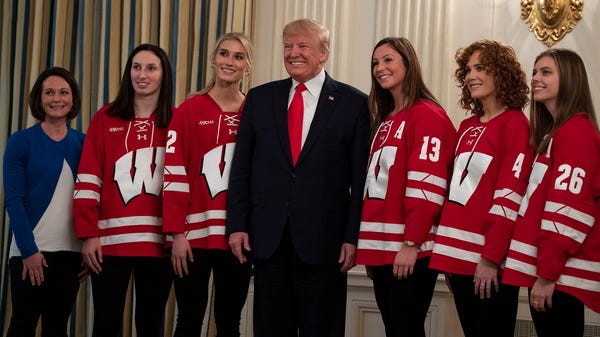 President Donald Trump poses for photos with membe