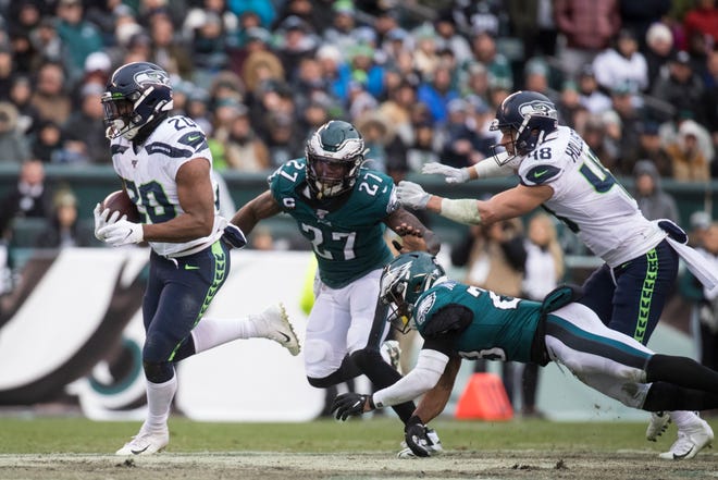 Seattle's Rashaad Penny (20) runs away from Philadelphia's Malcolm Jenkins (27) and Rodney McLeod (23) to go on and score Sunday at Lincoln Financial Field. The Seahawks defeated the Eagles 17-9.