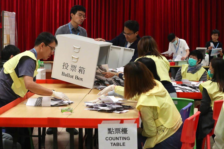 Election workers empty a ballot box to count votes at a polling station in Hong Kong, Sunday, Nov. 24, 2019.