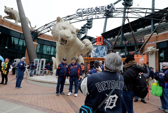 Detroit Tigers fans stand in front of the Tiger statue outside Comerica Park on Opening Day 2019.